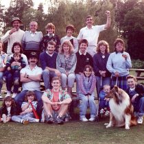 Families connected to the factory at a social event pose for the camera as a group, including a dog 2013.