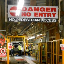 Warning sign above narrow section of production line reads 'Danger No Entry - no pedestrian access' 2013.
